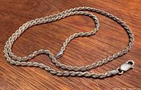 Full view of rope chain laid flat on wood surface