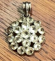 Front view of sterling silver cluster pendant showing yellow stones and bail