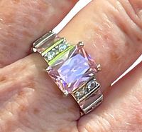 Ring on finger showing top view with pink center stone and clear accents