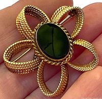 Front view of gold-filled flower brooch showing onyx centre and textured petals