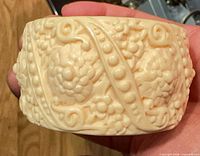 Overall view of carved cream resin cuff showing floral relief