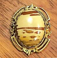 Front view showing oval picture jasper and ornate gold-tone frame