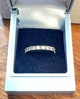 Ring in presentation box showing front view of half-eternity band