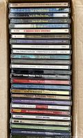 Stack of CDs in box showing spines from top to mid-stack