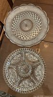 Both round pressed glass platters side by side