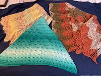 Three knit items laid flat showing colours and stitch patterns