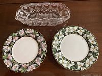 Top view of two floral plates and clear glass tray