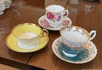 Three Royal Albert teacup and saucer sets displayed on table
