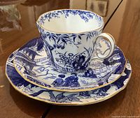 Cup resting on saucer and plate showing pattern and gold trim