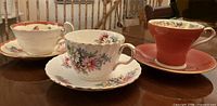 Three teacup and saucer sets displayed on table