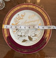 Top view of 10" Royal Ascot 40th Anniversary plate with measuring tape