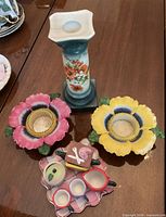 Front view of all items – candle holder, two flower tea light holders, miniature tea set on tray