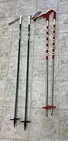 two pairs of ski poles laid out on floor