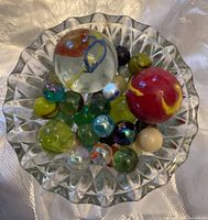 Top view of assorted marbles in a glass dish