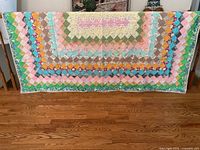 Full view of quilt front showing multicolour diamond patchwork design