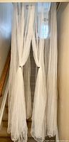 Full length view of white canopy net hanging down staircase