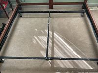 Adjustable metal bed frame with center rail and casters