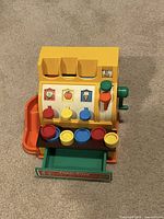 Front view of Fisher-Price toy cash register with coins in drawer