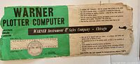 Front of Warner Plotter Computer showing brand, protractor graphic and caution note