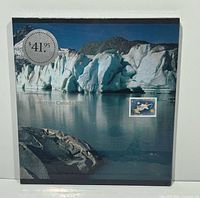 Front view of sealed album showing glacier artwork and affixed sample stamp