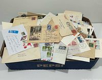 Top view of Pepsi box filled with assorted covers and postcards