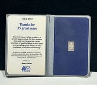 Open presentation case showing printed message and silver wafer