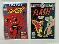 Front covers of both comic books showing titles, issue numbers, cover prices, and protective bags/boards