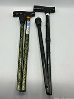 Both folding canes fully collapsed side-by-side showing handles, shafts and tips