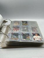 Binder closed showing thickness and pocket pages filled with sports cards