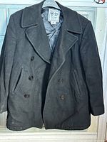 Front view of pea coat showing double-breasted design, buttons, pockets, collar