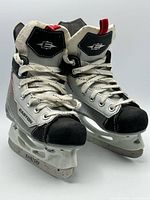 Front angled view of both skates showing tongues, laces, toe caps, and blade holders.