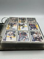 Binder open showing nine trading cards per sleeve