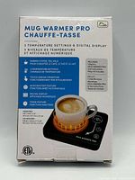 Retail box front showing product name, features and image of warmer with mug