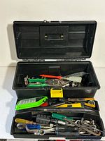 full view of open black plastic toolbox with mixed tools visible