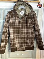 Front view of plaid hooded jacket on hanger