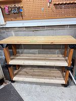 Front view of three-tier wood shelf showing overall structure