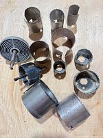 Overview of all hole saw cups, arbors, and adjustable cutter heads on workbench