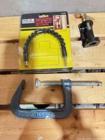 Lot overview showing C-clamp, packaged flexible drill extension, and clamp mount