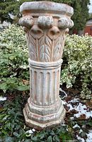 Full view of pedestal among garden foliage