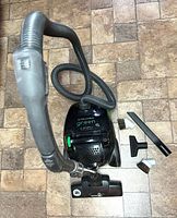 Top view of Electrolux Green canister vacuum with hose, wand and attachments visible