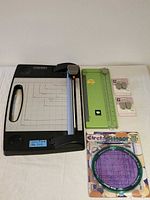 Lot overview showing Fiskars rotary cutter, Cricut trimmer, Circle Scissor tool in package, and two Cricut scoring blade packs