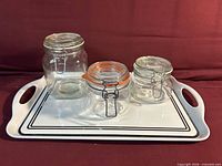 All three glass jars arranged on white tray showing relative sizes and overall lot contents