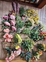 All artificial flower stems laid out on wooden floor