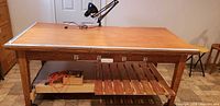 Front view of wood workbench showing top, outlet, shelf