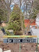 Front view of the metal garden sign showing text, motifs, stakes, and condition