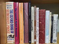 Shelf showing spines of thirteen books including Oxford Book of Humorous Prose and others
