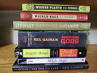 Stack of seven paperback books showing all titles and authors