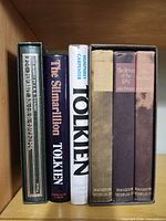 Six Tolkien books: green slipcased Hobbit, Silmarillion, Tolkien biography, three-volume LOTR set in black slipcase