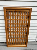Front view of rectangular wooden lattice trellis against siding