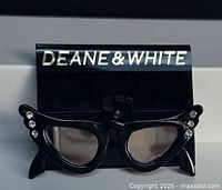 Front view of brooch on branded card showing full cat-eye frame and rhinestones